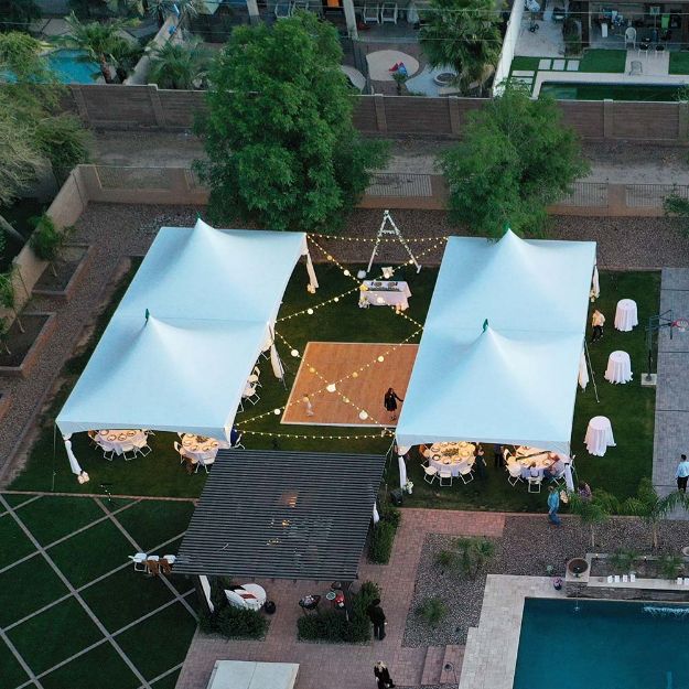 Dancing Under the Stars backyard wedding with four 20' x 20' rental tents and cross lighting over the dance floor.